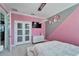 Pink bedroom featuring a bed, TV, and a unique accent wall at 9401 93Rd St, Seminole, FL 33777