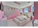 Pink bedroom with tufted headboard, decorative wall flowers, and modern chandelier at 9401 93Rd St, Seminole, FL 33777