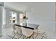 Bright dining room with a black table, white chairs, elegant chandelier, and textured wall at 9401 93Rd St, Seminole, FL 33777