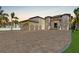 Expansive home featuring a tile roof, portico entry, three-car garage and large brick driveway at 9401 93Rd St, Seminole, FL 33777