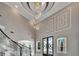 Grand foyer with a wrought iron staircase, modern chandelier and high ceilings at 9401 93Rd St, Seminole, FL 33777