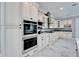 Spacious kitchen boasts white cabinetry, stainless appliances, and sleek marble flooring at 9401 93Rd St, Seminole, FL 33777