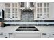 Stunning kitchen features stainless vent hood, black cooktop and custom tiled backsplash at 9401 93Rd St, Seminole, FL 33777