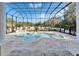 Beautiful outdoor pool area with lush landscaping, a built-in grill and spa under a screened enclosure at 9401 93Rd St, Seminole, FL 33777