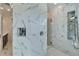 White marble tiled walk-in shower with mosaic stone floor and various shower head options at 9401 93Rd St, Seminole, FL 33777