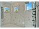 Luxurious shower space with marble tile, dual shower heads, and bright natural light at 9401 93Rd St, Seminole, FL 33777