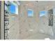 Marble tiled shower with dual shower heads and mosaic tile flooring with exterior windows at 9401 93Rd St, Seminole, FL 33777