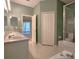 Bright bathroom featuring double sinks, large mirror, walk-in shower, toilet and closet at 10232 Grant Creek Dr, Tampa, FL 33647