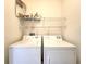 Bright laundry room featuring a white washer and dryer with wire shelving above for ample storage at 10232 Grant Creek Dr, Tampa, FL 33647
