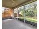 Enclosed screened porch with fan overlooking the backyard, perfect for outdoor relaxation and entertaining at 10232 Grant Creek Dr, Tampa, FL 33647
