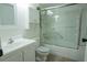 Bright bathroom featuring a shower-tub combo with sliding glass doors and vanity storage at 1433 Pine Glen Pl # G2, Tarpon Springs, FL 34688