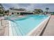 Community pool featuring a hot tub with safety rails, lounge chairs, and steps into the pool at 1433 Pine Glen Pl # G2, Tarpon Springs, FL 34688