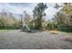 Community playground featuring a slide, seesaw, and spring rider surrounded by trees and green space at 1433 Pine Glen Pl # G2, Tarpon Springs, FL 34688