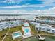 Expansive aerial view showcasing the waterway, shuffleboard courts, a pier, and nearby buildings at 1868 Shore S Dr # 209, South Pasadena, FL 33707