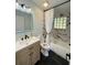 Bathroom featuring modern black fixtures, unique marble-look tiling and light wood vanity at 20 Cypress Dr, Palm Harbor, FL 34684