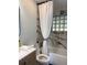 Close up of bathtub with white marble-look tiling with stylish shower curtain at 20 Cypress Dr, Palm Harbor, FL 34684