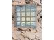 Close up of modern glass block window within the marble-look tiling of the bathtub at 20 Cypress Dr, Palm Harbor, FL 34684