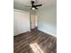 Bedroom features a ceiling fan, wood-look flooring, and a closet with louvered doors at 20 Cypress Dr, Palm Harbor, FL 34684