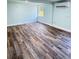Bright bedroom showcasing wood-look flooring, light blue walls, and a modern mini-split AC system at 20 Cypress Dr, Palm Harbor, FL 34684