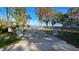 A gated driveway leading to the waterfront with a glimpse of the lake at 20 Cypress Dr, Palm Harbor, FL 34684