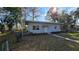 Exterior view of home with a manicured lawn and mature trees at 20 Cypress Dr, Palm Harbor, FL 34684