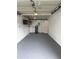 Spacious garage interior with white walls, gray floors, cabinets, and door at 20 Cypress Dr, Palm Harbor, FL 34684