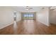 Spacious living room featuring wood flooring, a ceiling fan, and sliding glass doors to a balcony at 420 64Th Ave # 1005, St Pete Beach, FL 33706