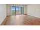 Empty living room featuring wood flooring, sliding glass doors to a balcony, and natural light at 420 64Th Ave # 1005, St Pete Beach, FL 33706
