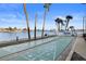 Community shuffleboard courts next to a lake with tropical landscaping at 420 64Th Ave # 1005, St Pete Beach, FL 33706