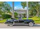 Elegant home with a classic car parked in front, surrounded by palm trees and lush greenery at 425 20Th Ne Ave, St Petersburg, FL 33704