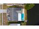 Aerial view of home with dark roof, pool, and waterfront access on a sunny day at 4728 Swallowtail Dr, New Port Richey, FL 34653