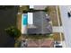Aerial view of a home with a pool and backyard on the water in a residential neighborhood at 4728 Swallowtail Dr, New Port Richey, FL 34653
