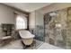 Beautiful bathroom featuring soaking tub, marble tiling, and glass-enclosed shower at 4728 Swallowtail Dr, New Port Richey, FL 34653