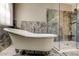 Modern clawfoot bathtub situated in a tiled bathroom with a glass enclosed shower at 4728 Swallowtail Dr, New Port Richey, FL 34653