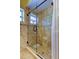 Modern shower featuring glass enclosure, tiled walls and flooring, and bronze finish fixtures at 4728 Swallowtail Dr, New Port Richey, FL 34653