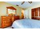 Bright bedroom featuring a wooden dresser with mirror and a closet, creating a comfortable and stylish space at 4728 Swallowtail Dr, New Port Richey, FL 34653