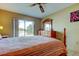 Bedroom featuring a wooden bed frame, matching dresser, a window overlooking a lake and ceiling fan at 4728 Swallowtail Dr, New Port Richey, FL 34653