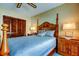 Bedroom with a four-poster bed, matching side tables, and a closet with wooden louvered doors at 4728 Swallowtail Dr, New Port Richey, FL 34653