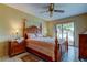 Primary bedroom with wooden furniture, ceiling fan, and glass sliding door with a view of the water at 4728 Swallowtail Dr, New Port Richey, FL 34653