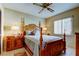 Cozy bedroom features a four-poster bed, side tables with lamps, large window and ceiling fan at 4728 Swallowtail Dr, New Port Richey, FL 34653