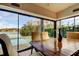 Inviting dining area featuring a wood table with views of the pool and lake through large windows, great for gatherings at 4728 Swallowtail Dr, New Port Richey, FL 34653