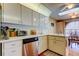 Clean kitchen with stainless steel dishwasher, white cabinets, and hardwood floors at 4728 Swallowtail Dr, New Port Richey, FL 34653
