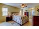 Cozy main bedroom with a ceiling fan, ensuite, and natural lighting from two windows at 4728 Swallowtail Dr, New Port Richey, FL 34653