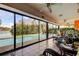 Sunroom overlooking the refreshing pool and lake with expansive glass windows, ideal for relaxation and enjoyment at 4728 Swallowtail Dr, New Port Richey, FL 34653