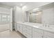 Bathroom featuring double sink vanity, large mirror, and views of tiled shower at 11683 Rose Gold Ct, Venice, FL 34293