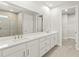 Bathroom featuring double sink vanity, large mirror, and a tiled shower at 11683 Rose Gold Ct, Venice, FL 34293