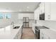 Bright kitchen featuring white cabinets, stainless steel appliances, quartz countertops, and light wood flooring at 11683 Rose Gold Ct, Venice, FL 34293