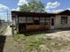 View of the back of the house with boarded up windows and a door, showing some needed repairs at 12812 1St Isle, Hudson, FL 34667
