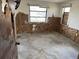 Stripped bedroom showing damage to walls, floor, and window frames at 12812 1St Isle, Hudson, FL 34667