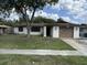 Modest single-story home with a brown roof, a front yard, and an attached one car garage at 12812 1St Isle, Hudson, FL 34667